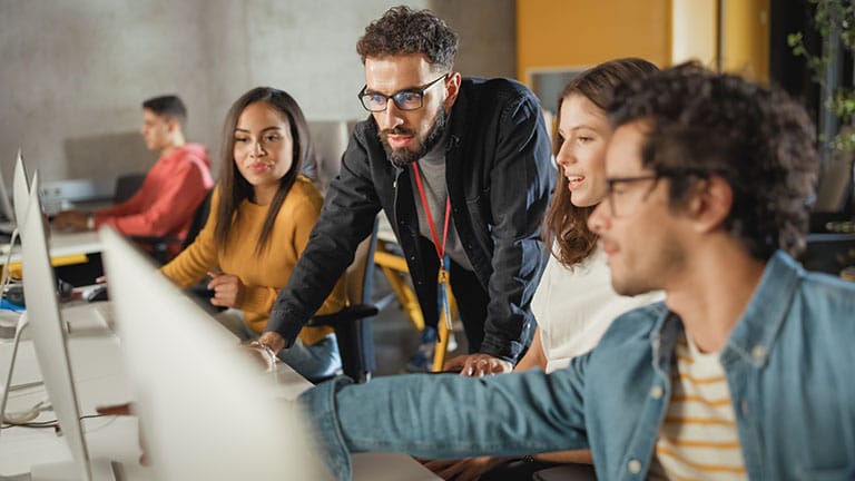 team of two women and 3 men looking at computer for cyber insurance