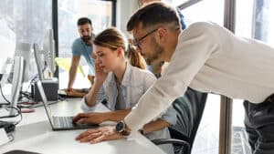 Man working with woman to tackle cyber attack on laptop